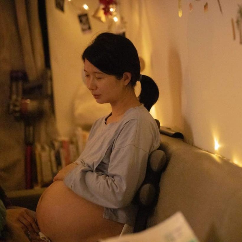 燭光下靜靜撫腹的孕婦