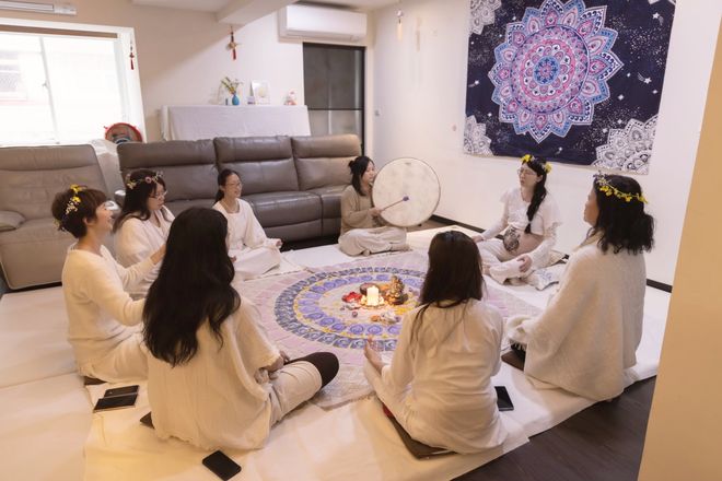 女人們圍坐成圈，中間是曼陀羅布與蠟燭