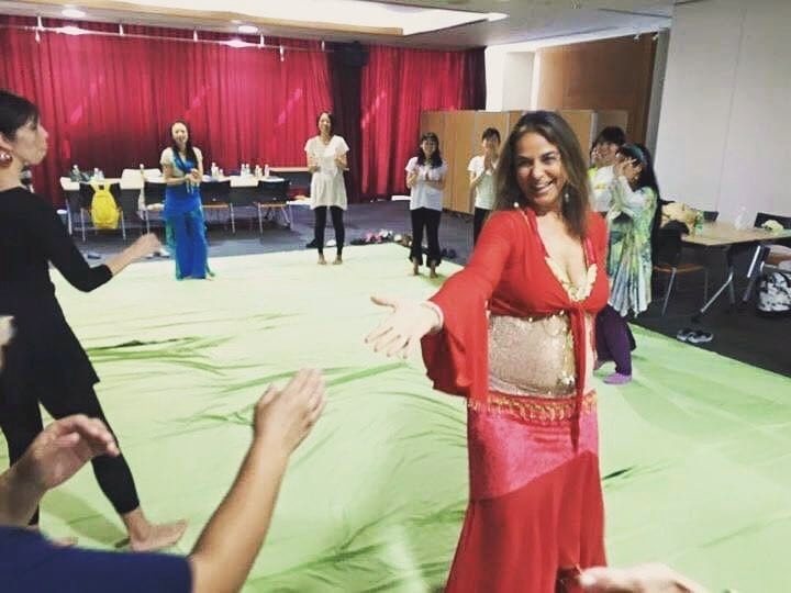 ワークショップで、両手を広げて参加者と一緒に舞うマハ